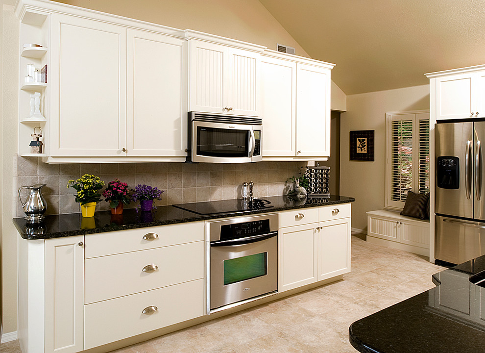 Inspiration for a mid-sized transitional galley porcelain tile eat-in kitchen remodel with shaker cabinets, white cabinets, granite countertops, beige backsplash, porcelain backsplash and stainless steel appliances