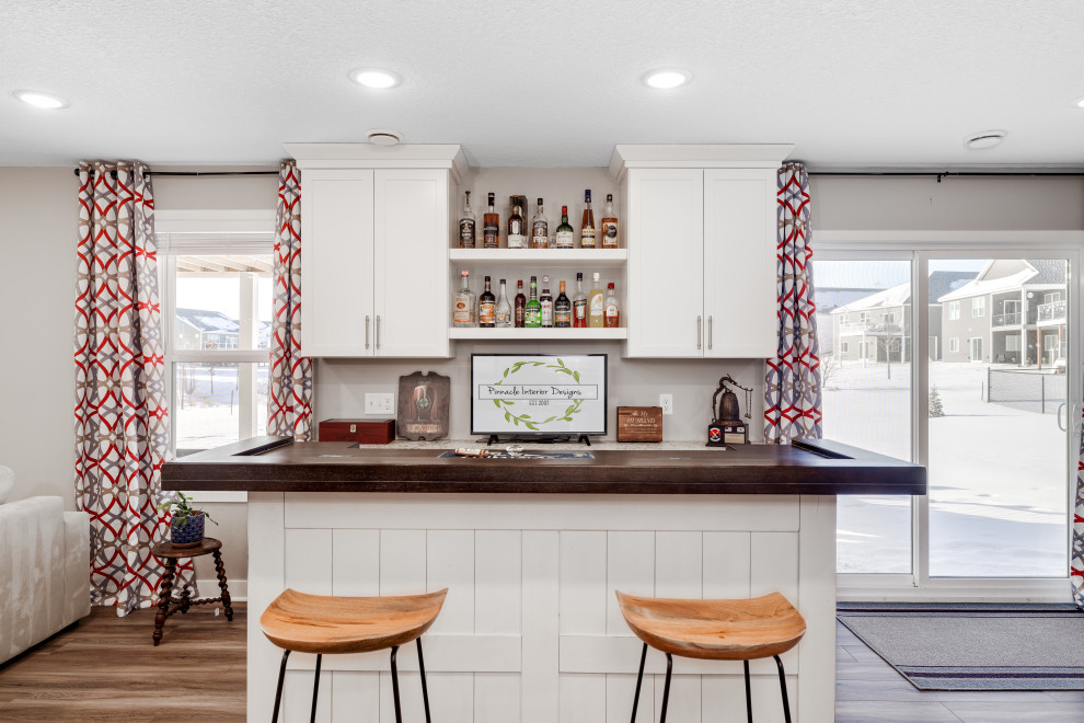 Idee per un angolo bar senza lavandino tradizionale di medie dimensioni con ante in stile shaker, ante bianche, top in legno, pavimento in vinile, pavimento marrone e top beige