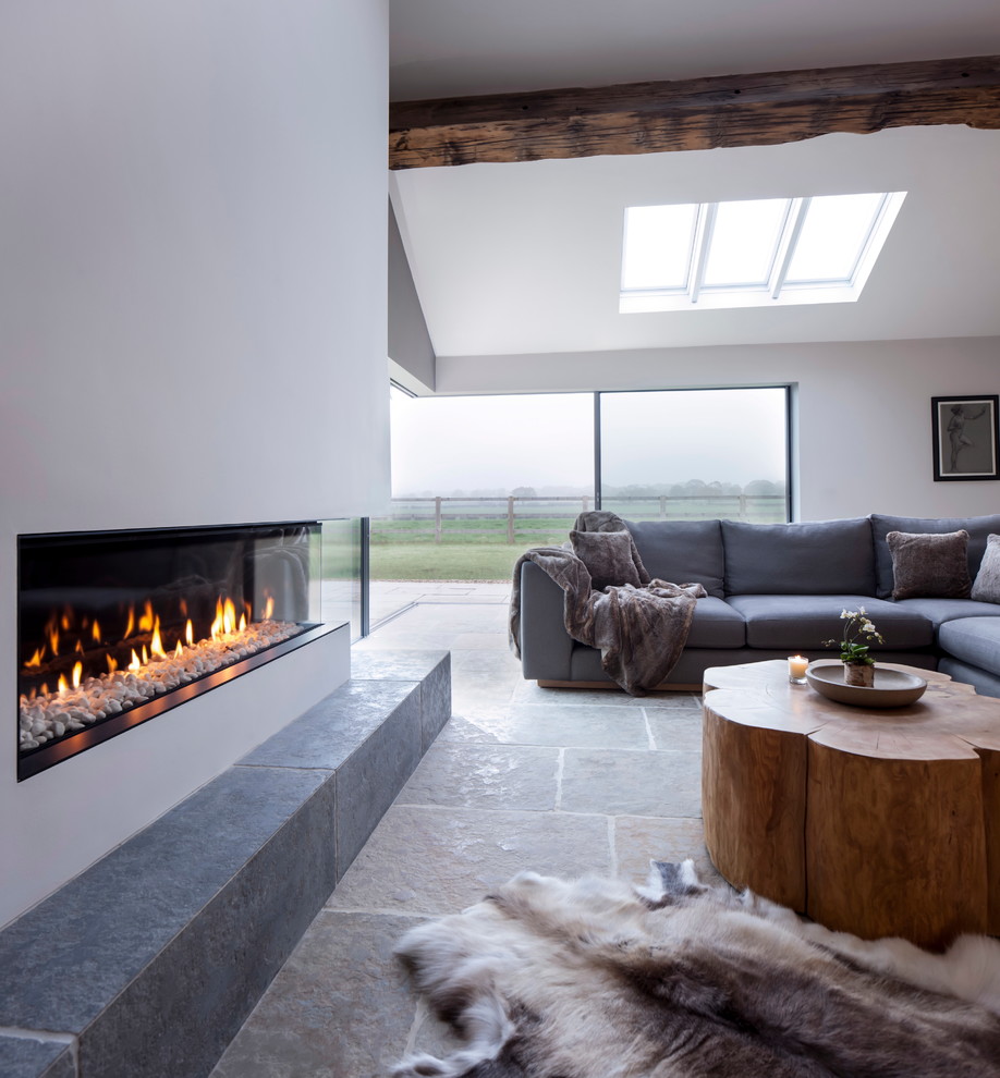 Design ideas for a large contemporary open concept living room in Cheshire with white walls, limestone floors, a plaster fireplace surround and a ribbon fireplace.