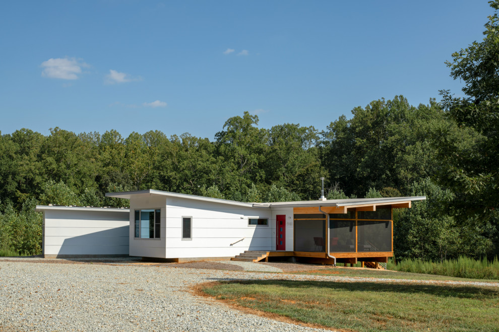 Inspiration för små moderna vita hus, med allt i ett plan, fiberplattor i betong, pulpettak och levande tak