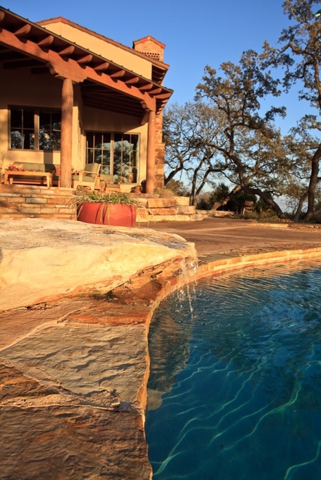 Mediterranean custom-shaped pool in Austin with natural stone pavers.