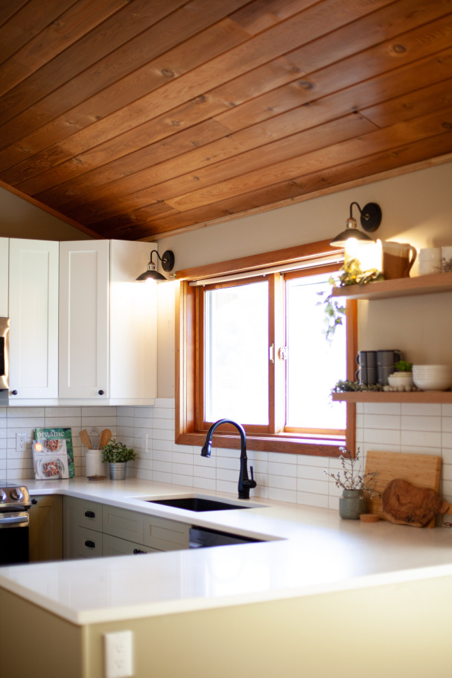 バンクーバーにあるお手頃価格の小さなモダンスタイルのおしゃれなキッチン (アンダーカウンターシンク、シェーカースタイル扉のキャビネット、緑のキャビネット、珪岩カウンター、白いキッチンパネル、セラミックタイルのキッチンパネル、シルバーの調理設備、コルクフローリング、オレンジの床、白いキッチンカウンター、板張り天井) の写真