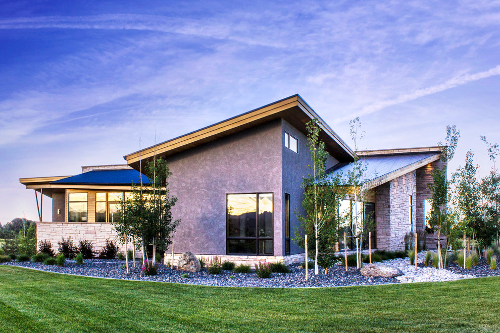 Photo of a large contemporary two-storey grey exterior in Denver with wood siding and a shed roof.