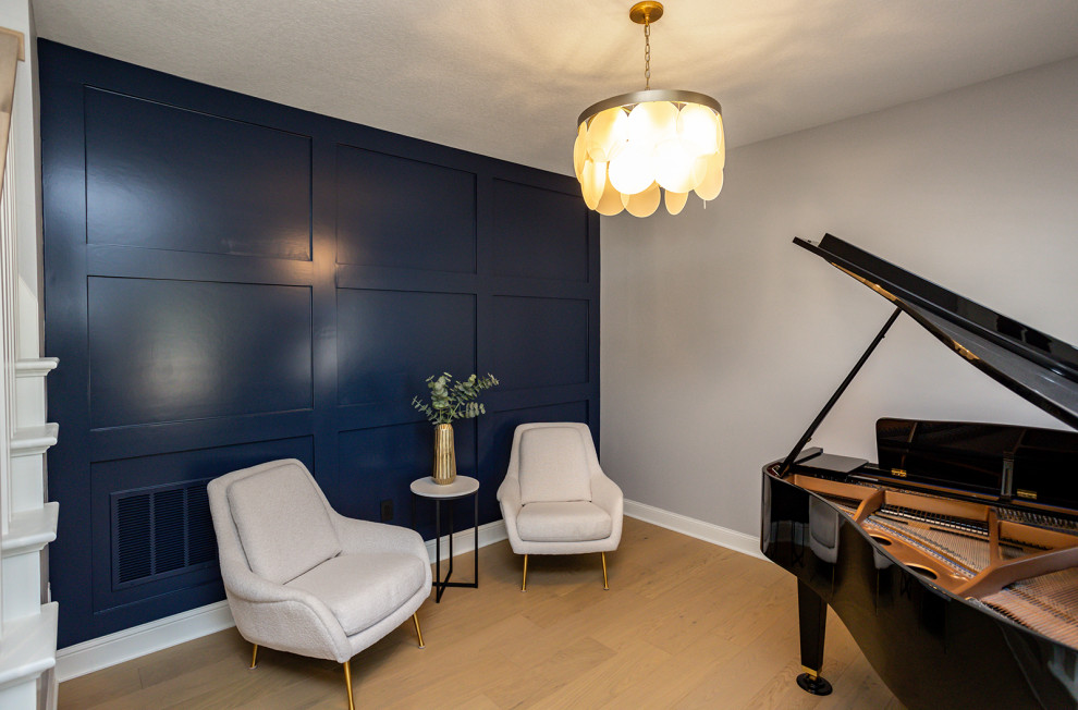 Klassisk inredning av ett mellanstort allrum med öppen planlösning, med ett musikrum, blå väggar, ljust trägolv och brunt golv