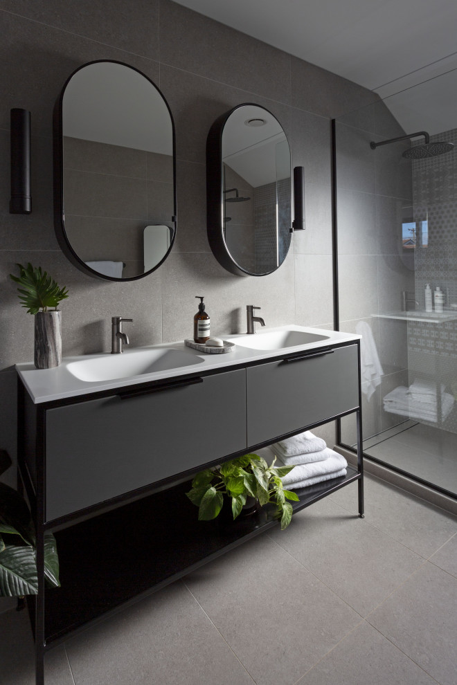 Foto på ett funkis vit en-suite badrum, med grå skåp, grå kakel, stenkakel, grå väggar, klinkergolv i keramik, bänkskiva i akrylsten, grått golv och med dusch som är öppen