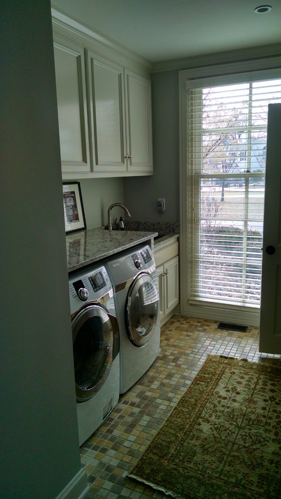 Small contemporary galley dedicated laundry room in St Louis with an undermount sink, raised-panel cabinets, white cabinets, granite benchtops, grey walls, ceramic floors and a side-by-side washer and dryer.