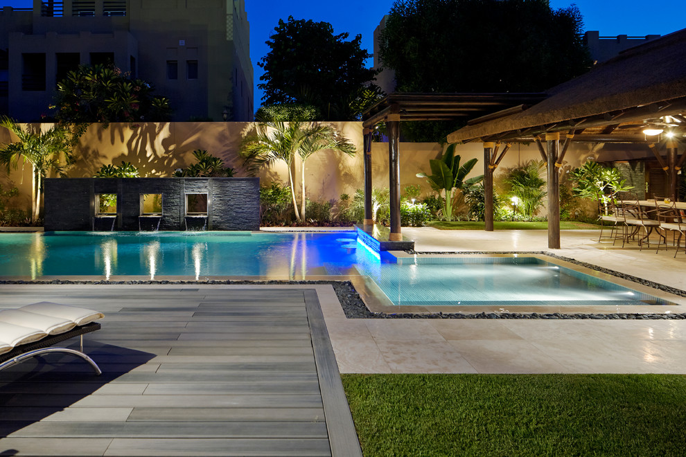 Inspiration for a mid-sized modern backyard l-shaped lap pool in Other with a water feature and tile.