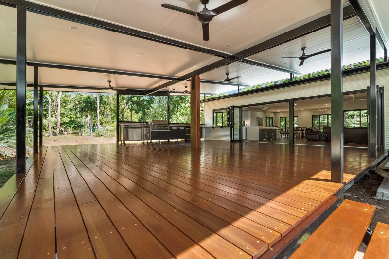 Expansive tropical backyard deck in Darwin with an outdoor kitchen and a roof extension.