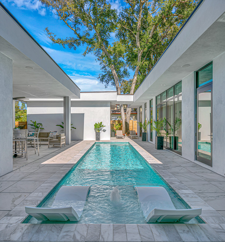 Large midcentury rectangular lap pool in Tampa with tile.