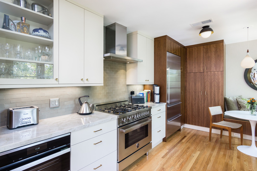 This is an example of a mid-sized midcentury galley separate kitchen in Los Angeles with an undermount sink, flat-panel cabinets, medium wood cabinets, quartzite benchtops, green splashback, ceramic splashback, stainless steel appliances and medium hardwood floors.