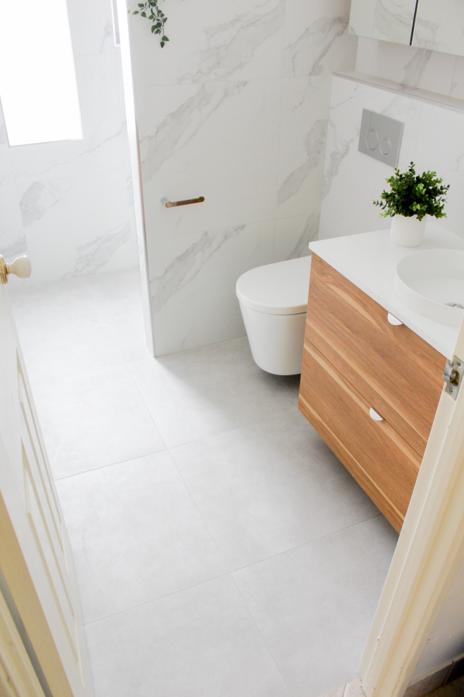 This is an example of a small modern 3/4 bathroom in Perth with flat-panel cabinets, distressed cabinets, an open shower, a wall-mount toilet, white tile, porcelain tile, white walls, porcelain floors, a vessel sink, engineered quartz benchtops, grey floor, an open shower, white benchtops, an enclosed toilet, a single vanity and a floating vanity.