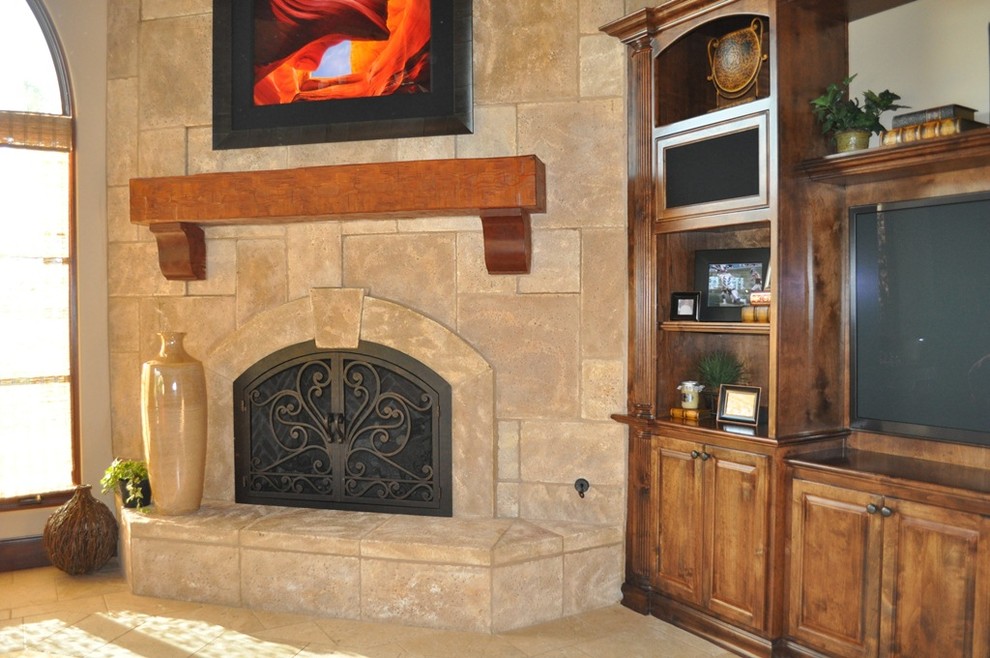 This is an example of a large traditional living room in San Diego with white walls, limestone floors, a corner fireplace, a stone fireplace surround, a wall-mounted tv and beige floor.