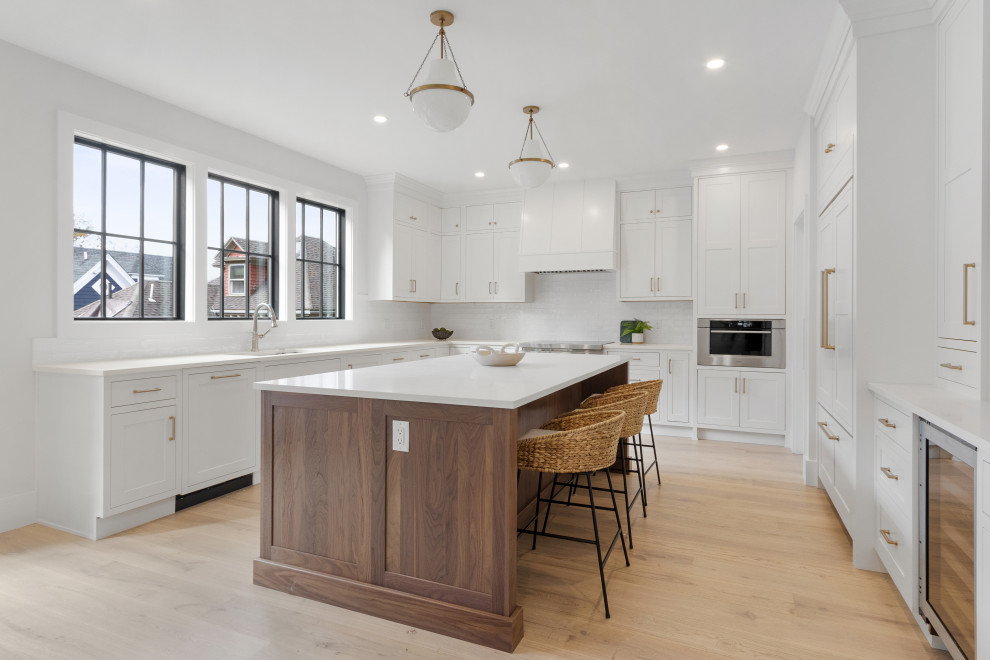 Inspiration for a transitional light wood floor kitchen remodel in Boston with shaker cabinets, white backsplash, subway tile backsplash and an island