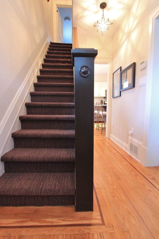 Photo of a small eclectic carpeted straight staircase in Toronto with carpet risers.
