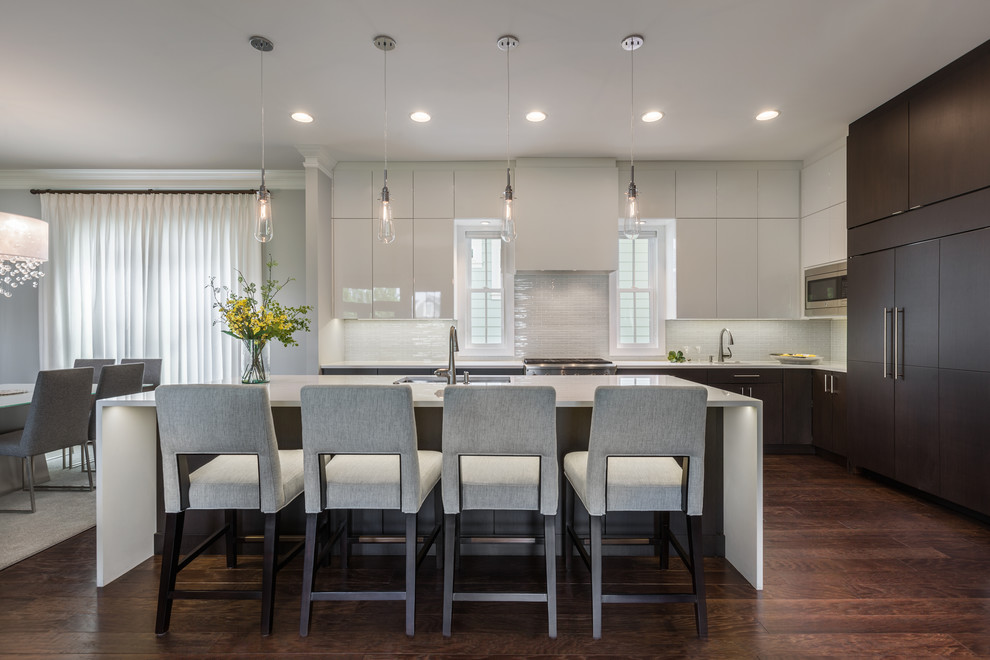 Photo of a contemporary l-shaped eat-in kitchen in Other with an undermount sink, flat-panel cabinets, white cabinets, quartz benchtops, white splashback, ceramic splashback, stainless steel appliances, dark hardwood floors, with island and brown floor.