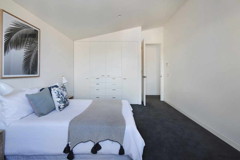 Large contemporary guest bedroom in Melbourne with white walls, carpet, no fireplace and grey floor.
