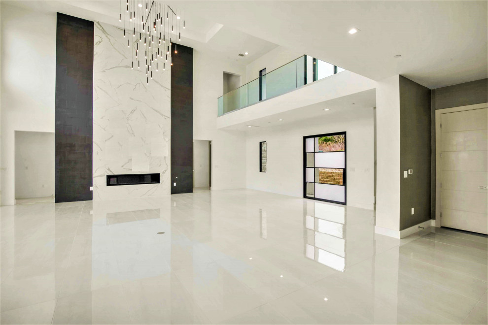 Идея дизайна: большая парадная, открытая гостиная комната в стиле модернизм с белыми стенами, полом из керамогранита, фасадом камина из плитки, телевизором на стене, белым полом, кессонным потолком и обоями на стенах
