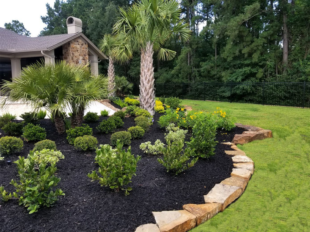 Inspiration for a mid-sized contemporary backyard partial sun formal garden in Houston with with flowerbed and mulch.