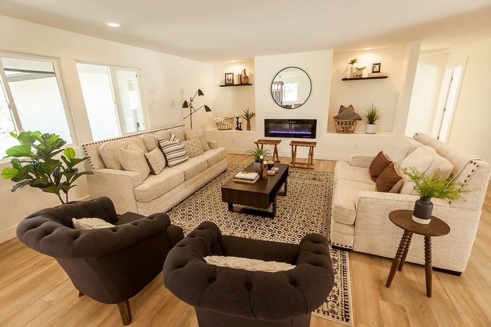 Mid-sized contemporary formal open concept living room in San Luis Obispo with beige walls, light hardwood floors, a ribbon fireplace, a plaster fireplace surround, no tv and beige floor.