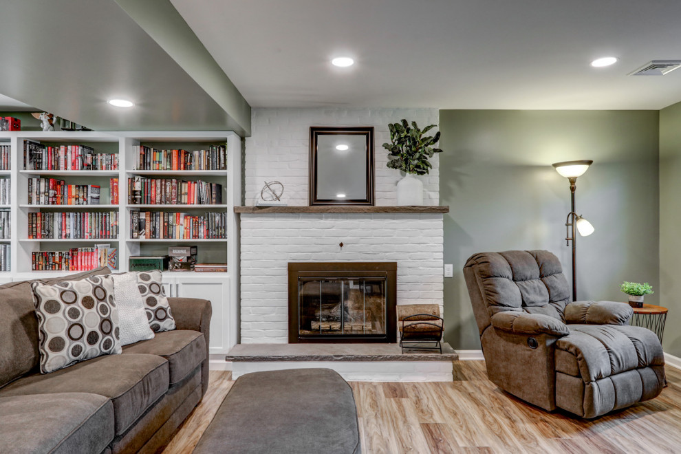 Inspiration for a large traditional walk-out basement in Other with green walls, vinyl flooring, a standard fireplace, a brick fireplace surround and brown floors.