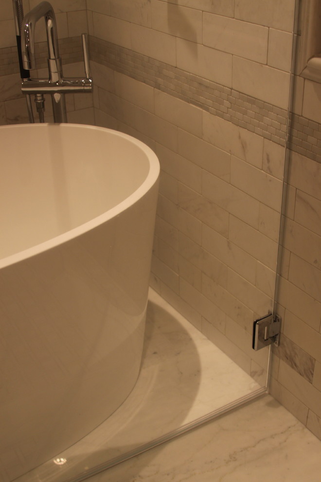 Mid-sized transitional master multicolored tile and stone tile marble floor freestanding bathtub photo in Atlanta with a vessel sink, beaded inset cabinets, beige cabinets, marble countertops, a one-piece toilet and gray walls