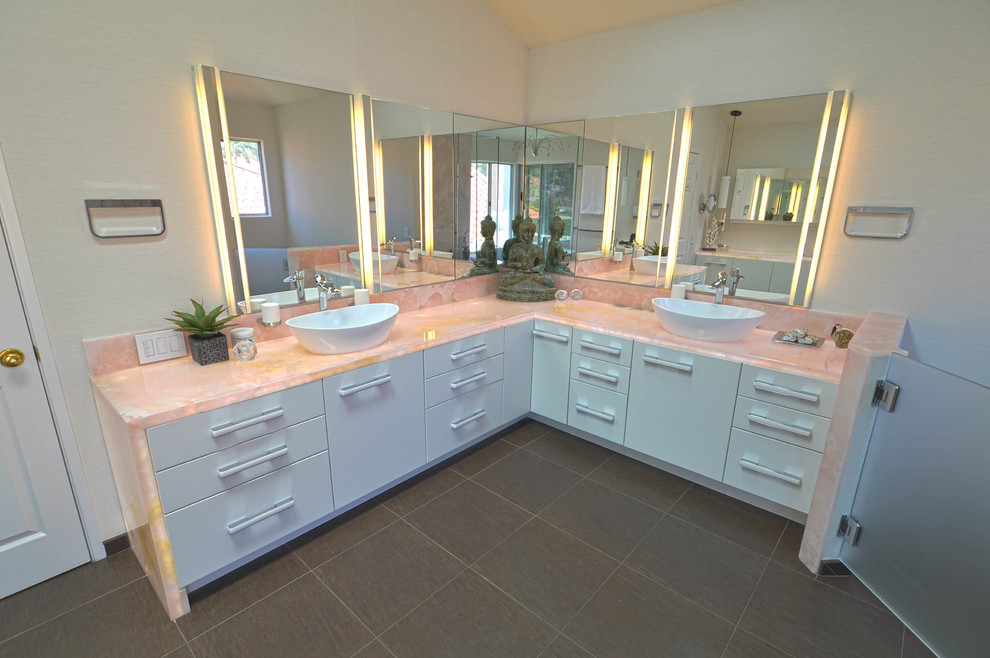 Inspiration for a large contemporary master bathroom in San Diego with a vessel sink, flat-panel cabinets, white cabinets, onyx benchtops, a freestanding tub, a curbless shower, a bidet, brown tile, porcelain tile, white walls and porcelain floors.