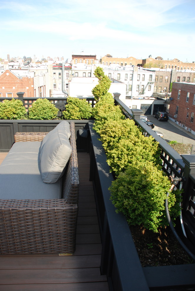 This is an example of a mid-sized contemporary rooftop deck in New York with an outdoor kitchen and a pergola.