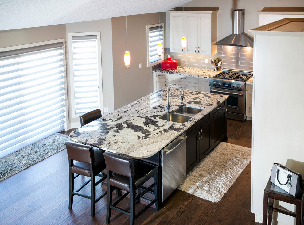 Mid-sized modern galley eat-in kitchen in Edmonton with a double-bowl sink, flat-panel cabinets, white cabinets, granite benchtops, grey splashback, ceramic splashback, stainless steel appliances and medium hardwood floors.