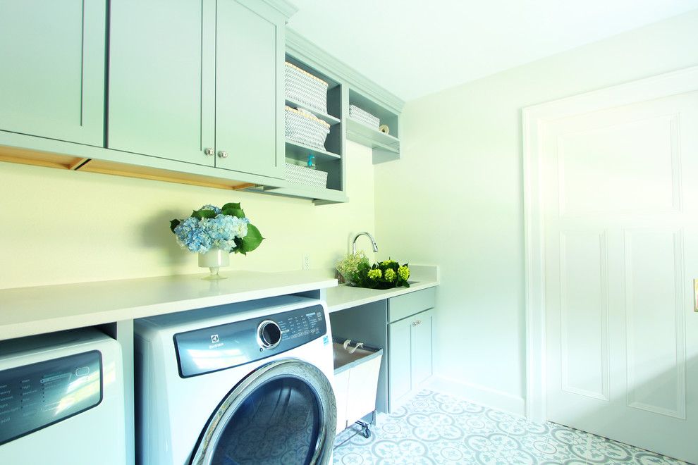 Example of a mid-sized transitional galley porcelain tile and multicolored floor dedicated laundry room design with an undermount sink, shaker cabinets, blue cabinets, quartz countertops, white walls, a side-by-side washer/dryer and white countertops