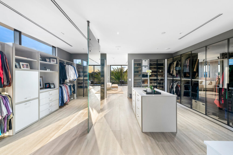 Walk-in closet - large modern gender-neutral walk-in closet idea in Miami with glass-front cabinets and white cabinets