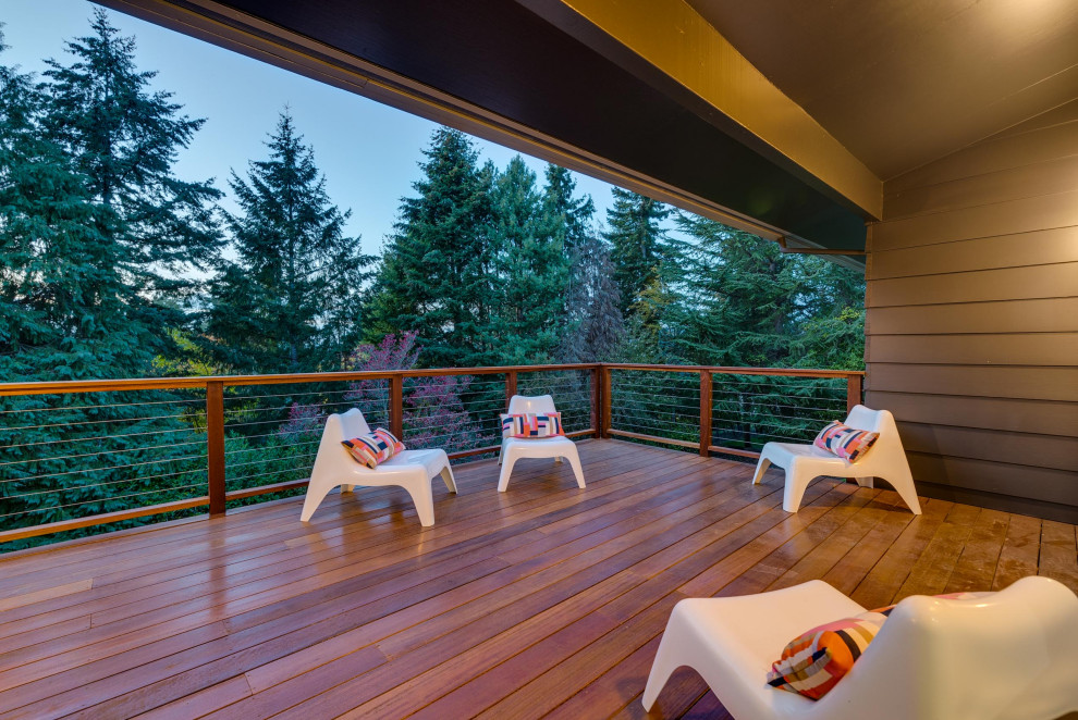 Expansive midcentury backyard deck in Portland with cable railing.