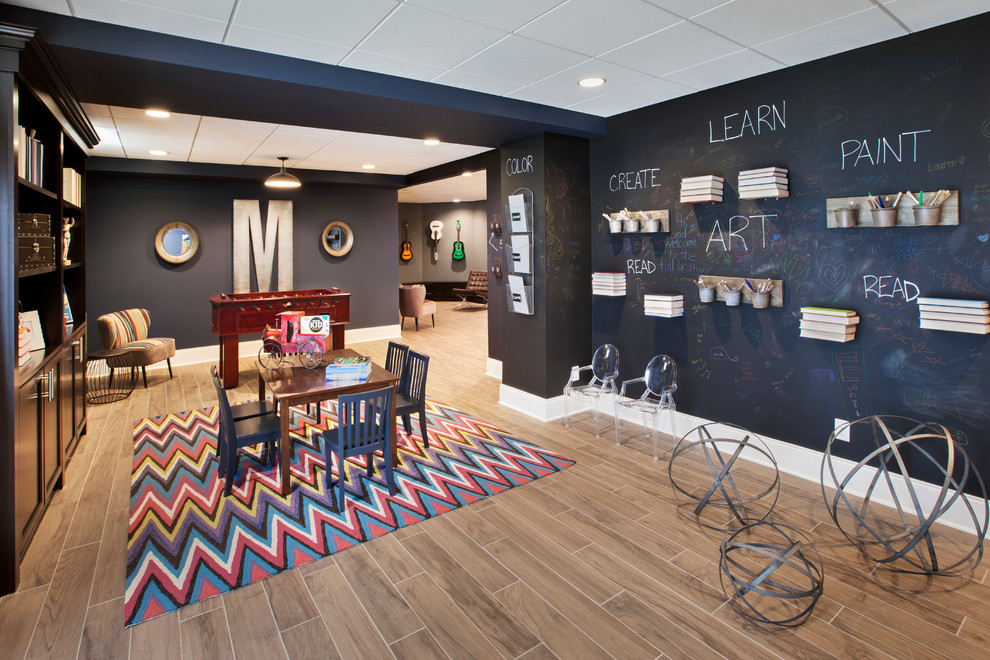 Example of a large transitional gender-neutral brown floor playroom design in Detroit with black walls