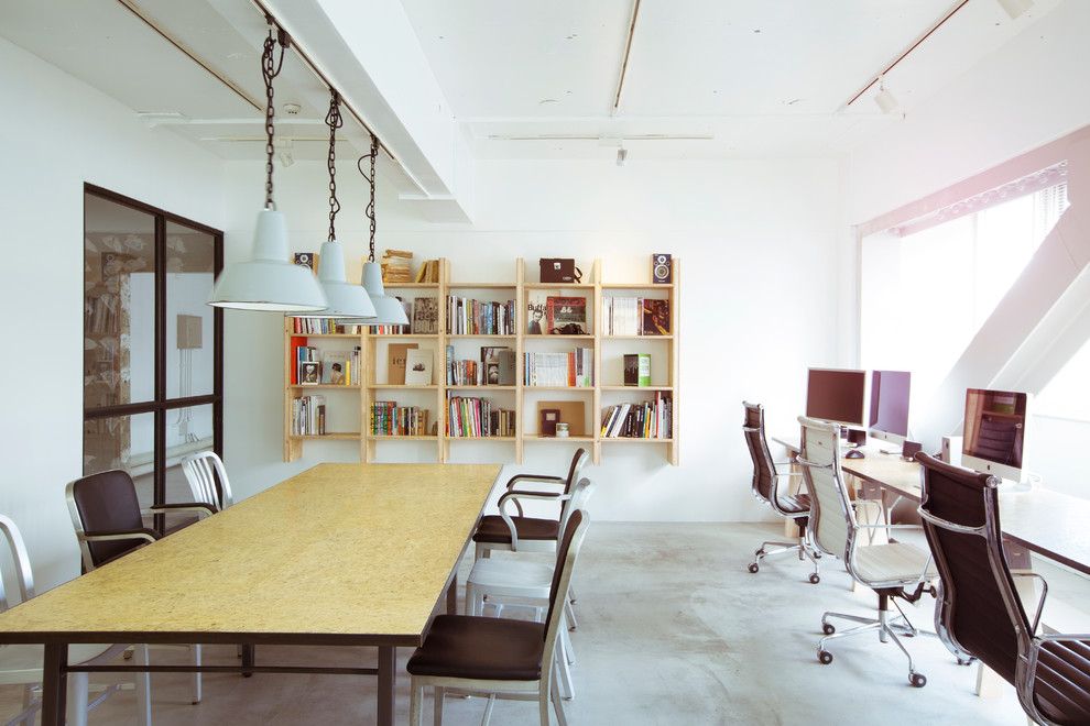 This is an example of a contemporary home studio in Tokyo with white walls, concrete floors and a freestanding desk.