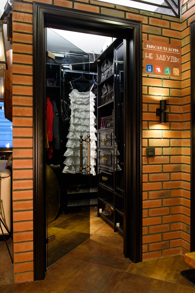 Photo of a small industrial gender-neutral walk-in wardrobe in Moscow with black cabinets, open cabinets and brown floor.