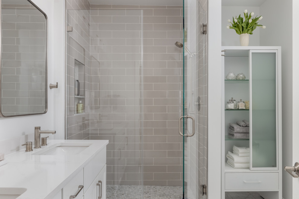 Example of a mid-sized transitional master gray tile and ceramic tile porcelain tile, gray floor and double-sink alcove shower design in DC Metro with shaker cabinets, white cabinets, a two-piece toilet, white walls, an undermount sink, quartz countertops, a hinged shower door, white countertops, a niche and a built-in vanity