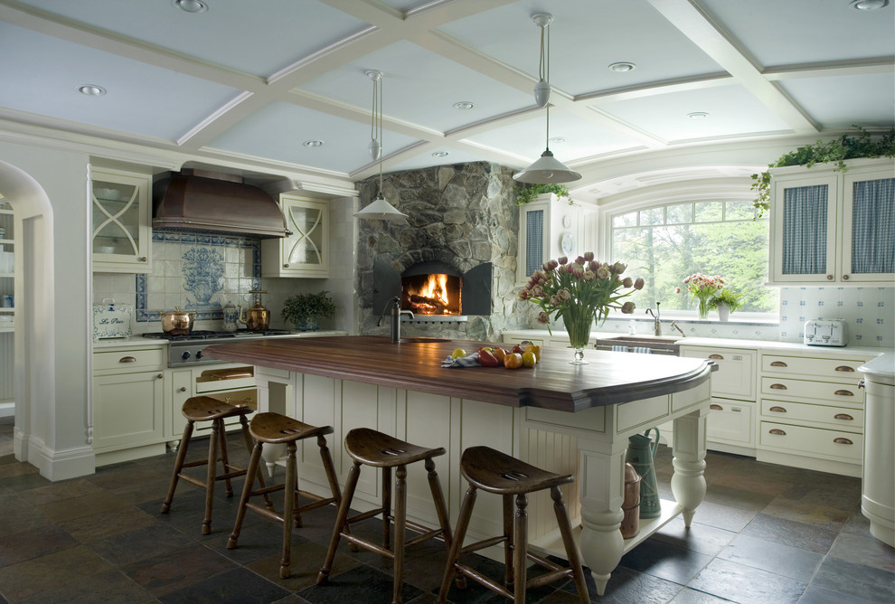Inspiration for an expansive traditional u-shaped separate kitchen in Boston with with island, a farmhouse sink, shaker cabinets, white cabinets, wood benchtops, white splashback, stone tile splashback, panelled appliances and multi-coloured floor.