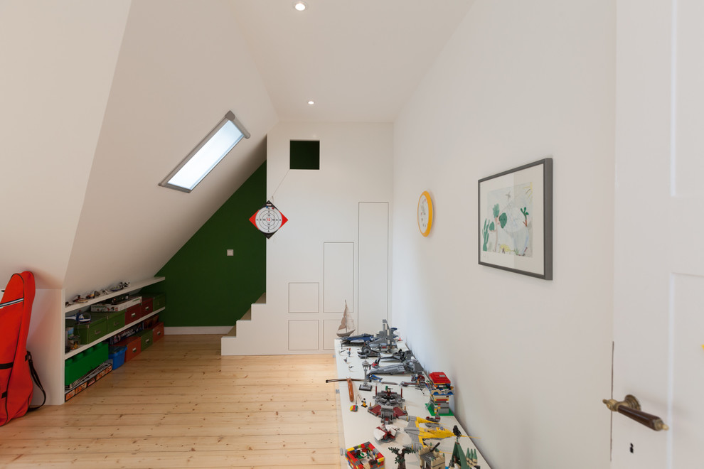 Photo of a mid-sized traditional kids' playroom for kids 4-10 years old and boys in Frankfurt with light hardwood floors and multi-coloured walls.