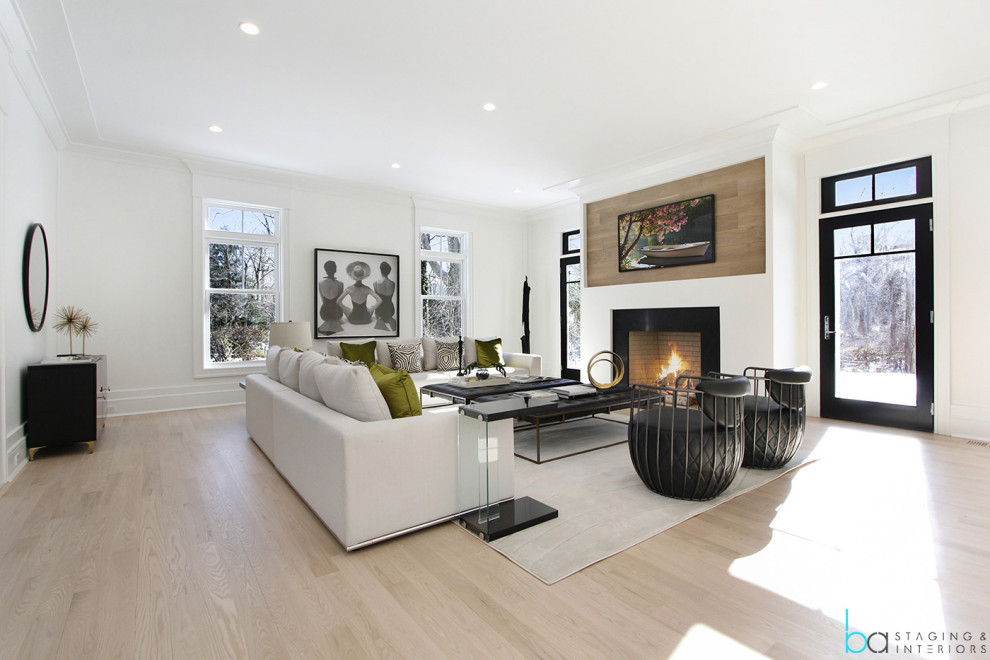 Design ideas for a large contemporary open concept living room in New York with white walls, light hardwood floors, a hanging fireplace, a stone fireplace surround, a wall-mounted tv and beige floor.