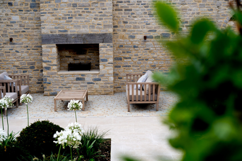 Inspiration for a patio in Oxfordshire with a bbq area and natural stone paving.
