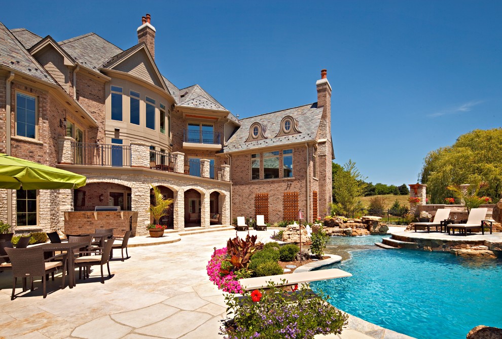 Inspiration for a large tropical backyard stone and custom-shaped water slide remodel in Chicago