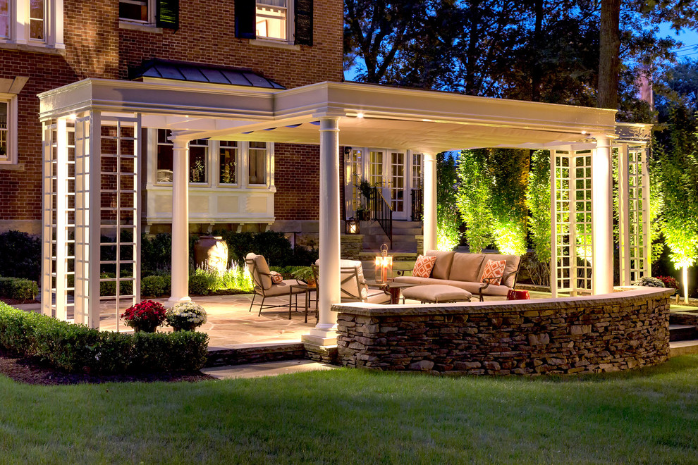 Traditional backyard patio in Toronto with concrete pavers and a pergola.