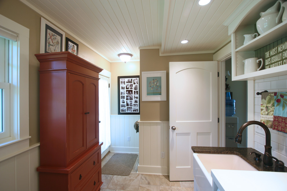 Design ideas for a small farmhouse single-wall separated utility room in Other with a belfast sink, shaker cabinets, white cabinets, composite countertops, beige walls, a side by side washer and dryer and beige floors.