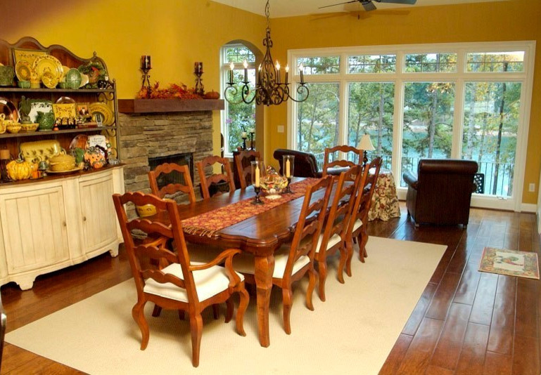 Dining room - mid-sized transitional dark wood floor dining room idea with yellow walls, a standard fireplace and a stone fireplace