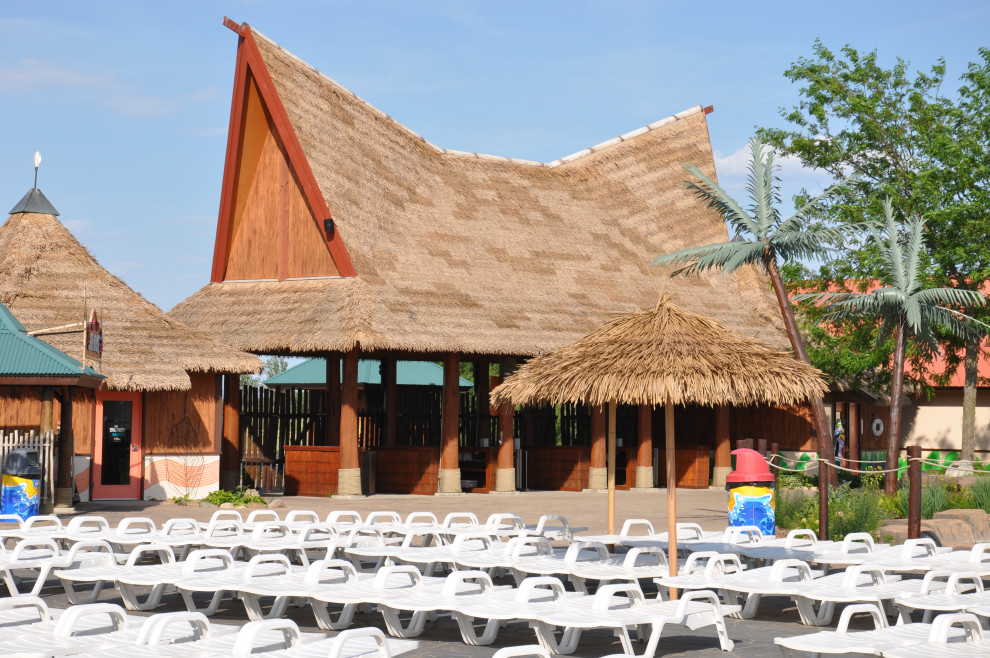 Foto de fachada verde y marrón tropical extra grande con revestimiento de madera, tejado de varios materiales y panel y listón