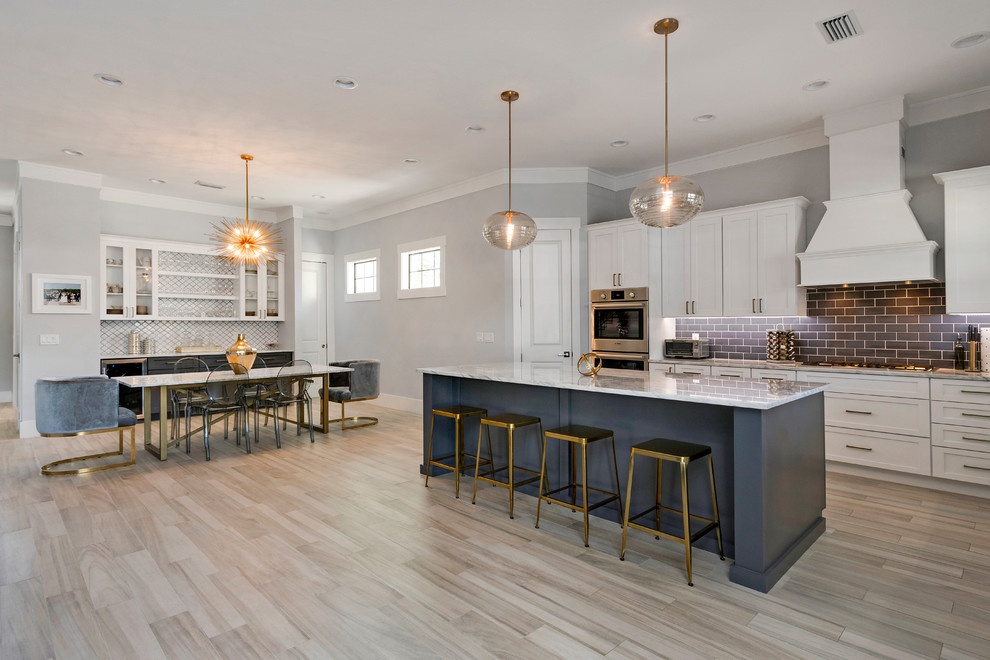 Design ideas for a large transitional l-shaped eat-in kitchen in Orlando with a farmhouse sink, white cabinets, marble benchtops, stainless steel appliances and with island.