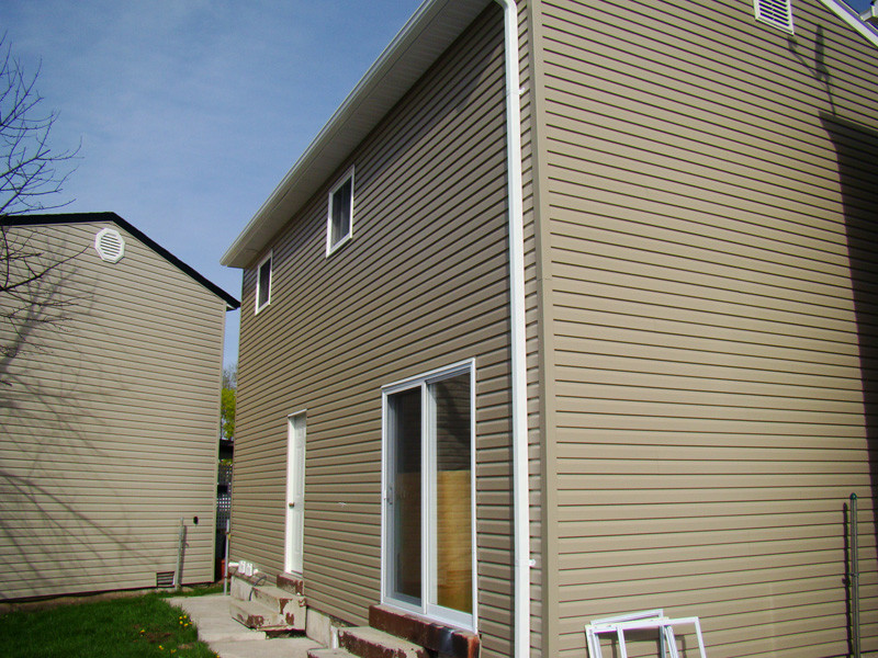 Mid-sized traditional two-storey beige exterior in Newark with vinyl siding and a gable roof.