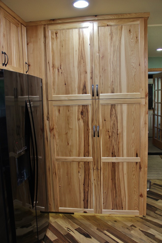 Example of a mid-sized mountain style l-shaped medium tone wood floor eat-in kitchen design in Minneapolis with an undermount sink, flat-panel cabinets, light wood cabinets, quartz countertops, black backsplash, glass tile backsplash, black appliances, red walls and no island