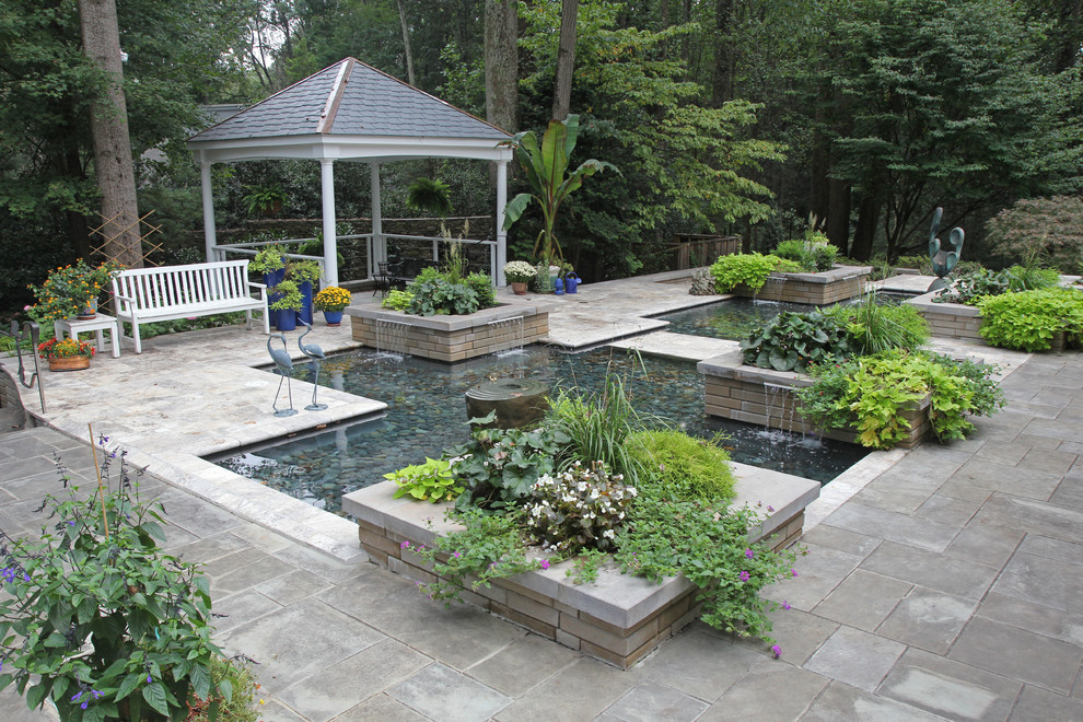 Mid-sized transitional backyard patio in DC Metro with a pergola and natural stone pavers.