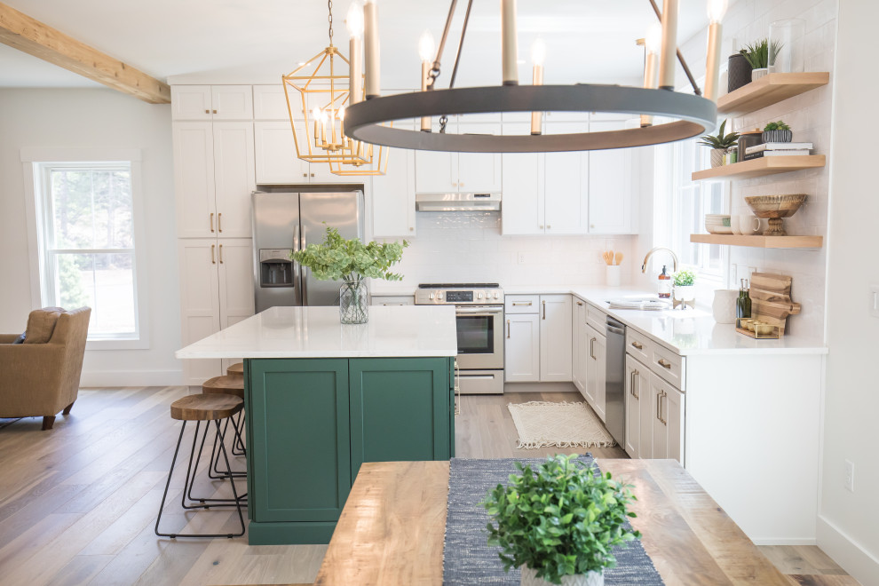 Inspiration for a large classic l-shaped kitchen/diner in Boston with a submerged sink, shaker cabinets, green cabinets, engineered stone countertops, white splashback, metro tiled splashback, stainless steel appliances, an island and white worktops.