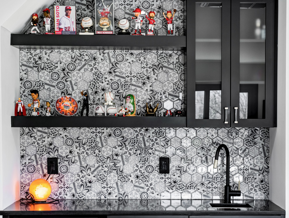 Photo of a small contemporary single-wall wet bar in Miami with a drop-in sink, flat-panel cabinets, black cabinets, quartzite benchtops, multi-coloured splashback, glass tile splashback and black benchtop.